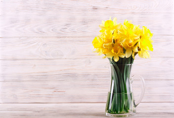 Daffodils over white wooden background