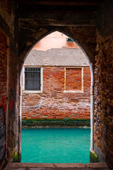 View of canal from arch of the building in Venice, Italy.