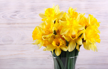 Daffodils over white wooden background