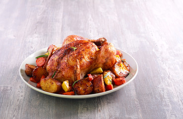 Roast chicken with vegetables on plate,