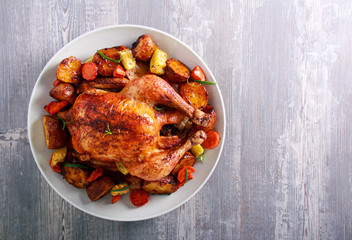Roast chicken with vegetables on plate
