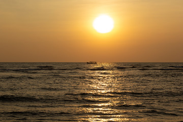 Obraz premium Landscape silhouette of a boat on the background of a magnificent sunset