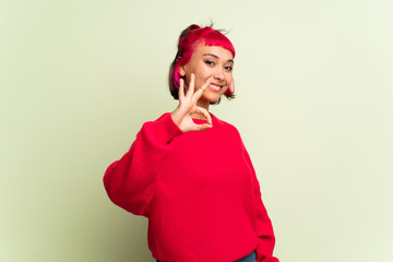 Young woman with red sweater showing an ok sign with fingers