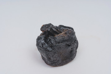 Spoiled mushroom champignon on a white background. Dried black mushroom. Improper preservation of...