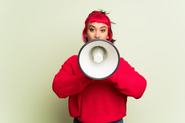 Young woman with red sweater shouting through a megaphone