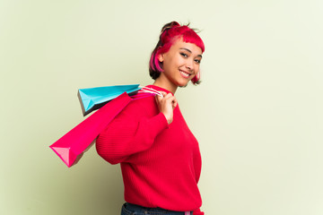 Young woman with red sweater holding a lot of shopping bags