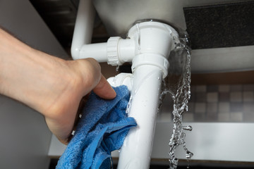 Male Hand's Holding Blue Napkin Under Leakage Pipe