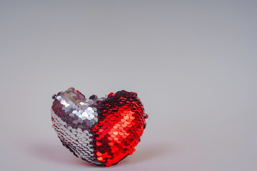 Key chain in the shape of a heart with double-sided sequins. Valentine's day gift. Texture of...