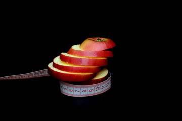 Sliced apple and measuring tape. Concept - apple diet