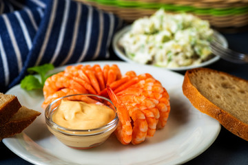 Boiled shrimps, bread and avocado salad on table.