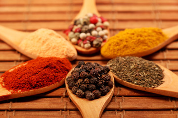 Group of indian spices and herbs difference ware in wooden spoons on wooden background with normal view and copy space for design foods, vegetable, spices, herbs, healthy lifestyle