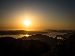 A beautiful and breathtaking view on fjords around Bergen, Norway, seen from the hill above the city. Endless fjords joining the sea. Sun sets over the horizon. Beauty of the nature.