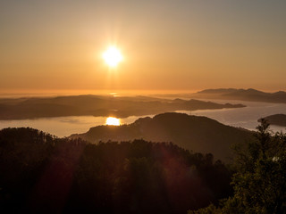 A beautiful and breathtaking view on fjords around Bergen, Norway, seen from the hill above the city. Endless fjords joining the sea. Sun sets over the horizon. Beauty of the nature.