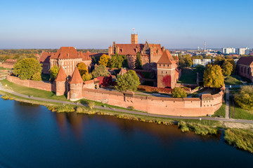 Medieval Malbork (Marienburg) Castle in Poland, main fortress of the Teutonic Knights at the Nogat river. Aerial view in fall in sunset light.