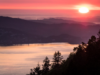 A beautiful and breathtaking view on fjords around Bergen, Norway, seen from the hill above the city. Endless fjords joining the sea. Sun sets over the horion. Beauty of the nature.