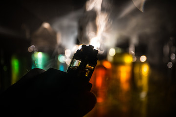 Vape concept. Electronic Cigarette vape explosion. Smoke clouds and vape liquid bottles on dark...