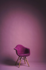 Chair on a light pink background. Studio paper background with props. Purple designer armchair with...