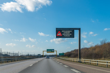A highway sign on a highway indicating strong wind