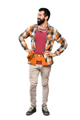 Craftsmen man posing with arms at hip and smiling over isolated white background