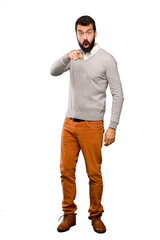 Fototapeta premium Handsome man surprised and pointing front over isolated white background