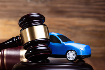 Gavel And Blue Car Near Law Book