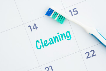 Schedule a dental cleaning message on a calendar with a toothbrush