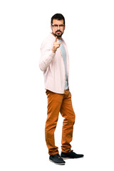 Full-length shot of Handsome man with beard frustrated and pointing to the front over isolated white background