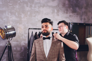 Mature professional Tailor taking measurements for sewing suit at tailors shop. Man with measuring tape busy. Exclusive Custom Made Cloth Concept.