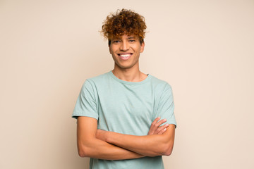 African american man with green shirt keeping the arms crossed in frontal position