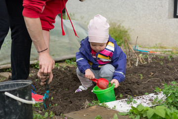 Small girl exploring the garden and helping with spring cleaning.