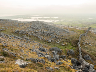 Dry stone wall in Burren national park, Ireland. Foggy morning.