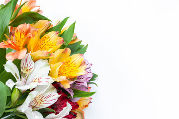 Bouquet of colorful flowers alstroemeria on white background. Flat lay. Horizontal. Mockup with copy space for greeting card, social media, flower delivery, Mother's day, Women's Day.