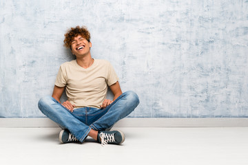 Young african american man sitting on the floor smiling