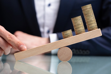 Businessperson Balancing Increasing Stacked Coins With Finger
