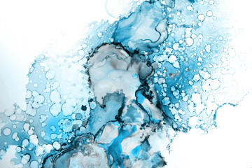 Blue alcohol ink texture with abstract washes and paint stains on the white paper background.	