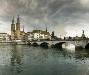 Zurich cityscape with many people crossing the river Limmat during the traditional spring festival of Sechselauten in April