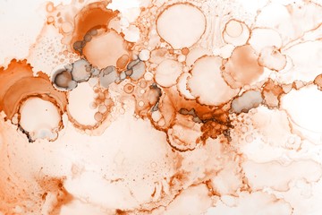 Orange alcohol ink texture with abstract washes and paint stains on the white paper background.	