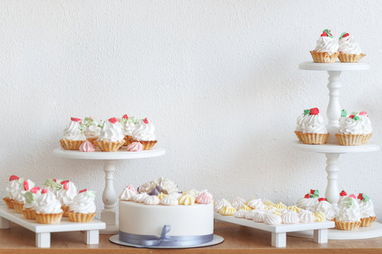 Cakes and sweets on a wooden shelf. The concept of decorating children's holiday.
