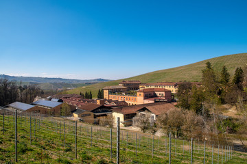 Fototapeta na wymiar High angle panoramic view of Fontanafredda, a winery founded in 1858 by King Victor Emmanuel II, surrounded by vineyard hills in springtime, Serralunga d'Alba, Langhe, Piedmont, Italy