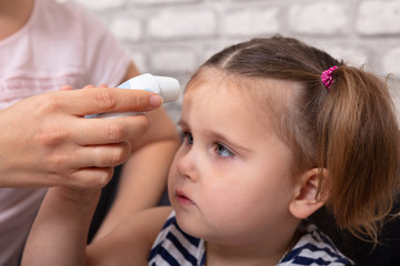 Mother Checking Fever Of Her Sick Daughter
