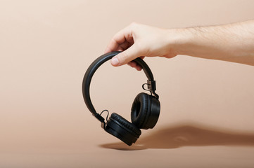 Man hand hold black headphones