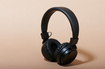 Fototapeta na wymiar Black headphones on beige color background