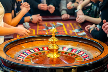 Casino. Roulette. A female croupier gives out a prize. Gambling Roulette table with players. Cash...