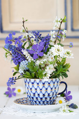 Fototapeta na wymiar Blumenstrauß in Weiß und Blau in Kaffeetasse als Dekoration