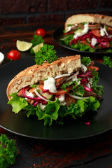 Doner kebab, fried lamb meat with vegetables and garlic sauce in turkish bread