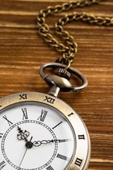 Vintage pocket watch clock on wooden background