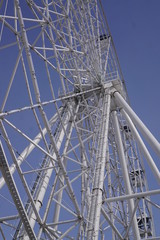 Part of the Ferris wheel against the blue sky.