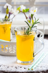 Fresh lemon drink with rosemary in glass cup