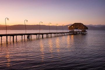 Fototapeta na wymiar Wooden dock and a rustic hut make up for a beautiful rural pier at the Gulf of Cariaco in Venezuela