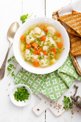 Vegetable soup with cauliflower, carrot, green peas, onion and potato